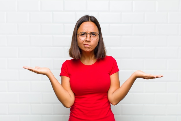 Femme latine à la perplexité, confuse et stressée, se demandant entre les différentes options, se sentant incertain