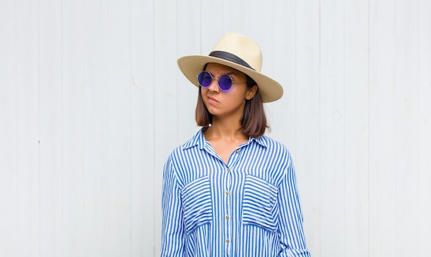 Femme latine à la recherche heureuse et sympathique, souriante et clignant des yeux avec une attitude positive