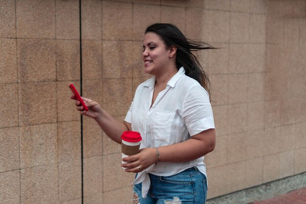 Femme latine regardant son téléphone portable dans la rue