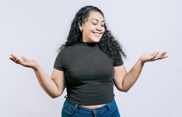 Photo femme latine souriante comparant avec les mains des palmiers isolées bonne fille équilibrant le produit avec les paumes isolées