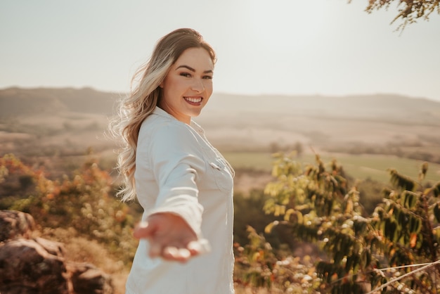 Femme latine tendant la main à la caméra, invitant à un voyage. Viens avec moi.