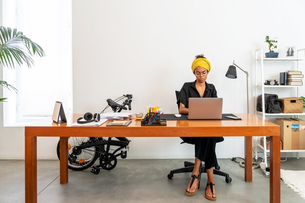 Photo femme latine travaillant au bureau à domicile avec ordinateur portable et documents