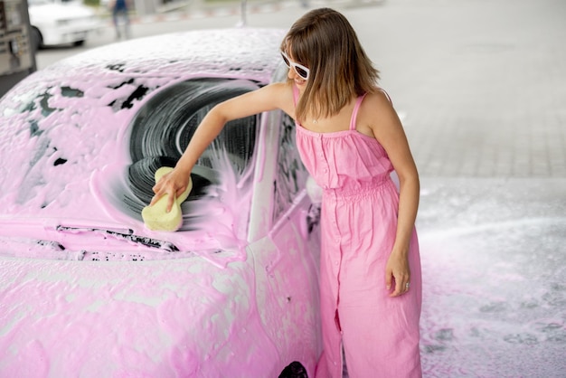 Femme lavant sa voiture au lave-auto en libre-service