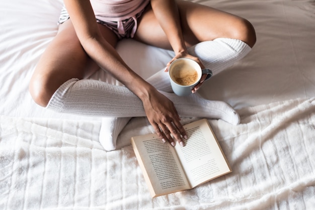 Femme, lecture, livre, boire, café, lit, chaussettes