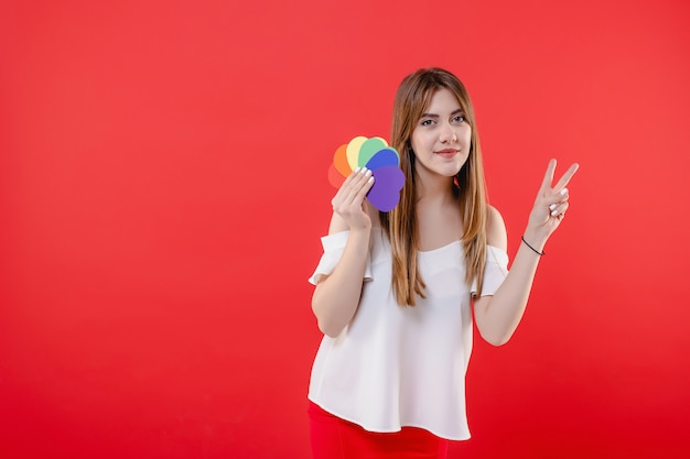 Femme lesbienne avec des formes de coeur de couleurs lgbt isolé sur rouge