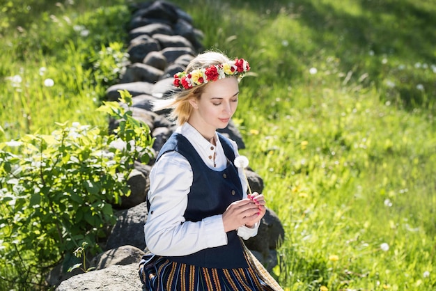 Femme lettone en costume traditionnel posant sur fond de nature dans le village festival de Ligo Riga Lettonie