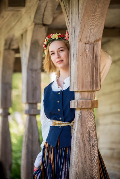 Femme lettone en vêtements traditionnels posant sur fond de nature dans le village de Ligo festival