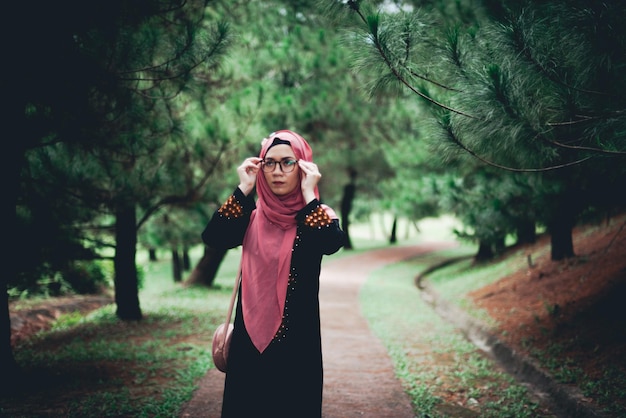 Photo femme levant les yeux alors qu'elle se tient contre dans le parc