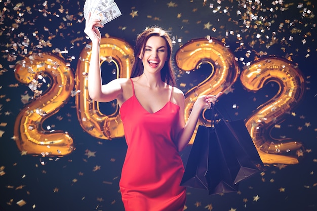 Une femme lève des dollars pour acheter des ballons du vendredi noir pour le nouvel an