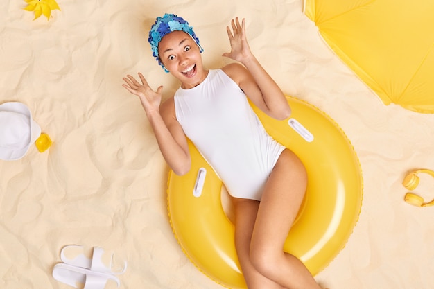 La Femme Lève La Main S'exclame Joyeusement Se Trouve Sur La Natation Aime Les Vacances Et L'heure D'été Réagit Aux Nouvelles Incroyables étant à La Plage Tropicale