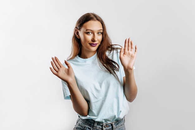 Femme lève ses mains STOP sur fond gris isolé