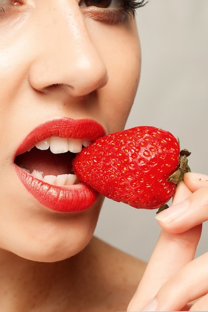 Femme, à, lèvres rouges, manger, fraise