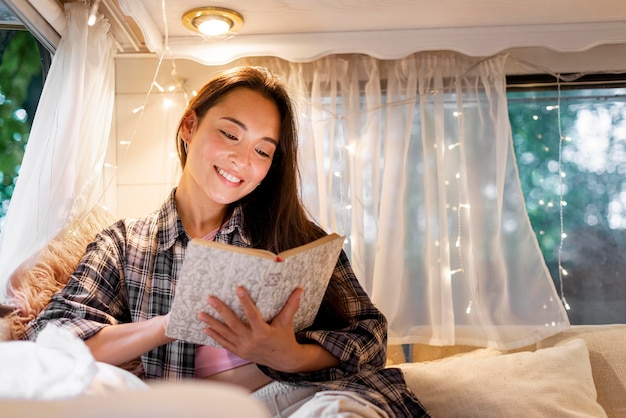 Photo femme lisant dans la camionnette