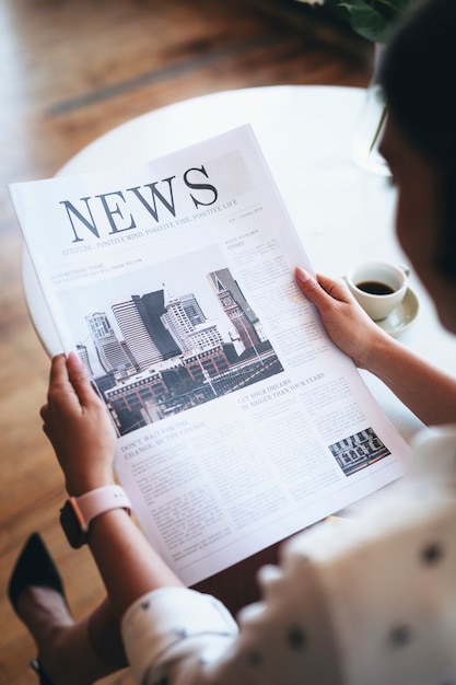 Femme lisant un journal dans un café