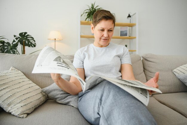 Femme lisant le journal à la maison