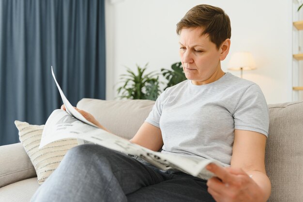 Femme lisant le journal à la maison