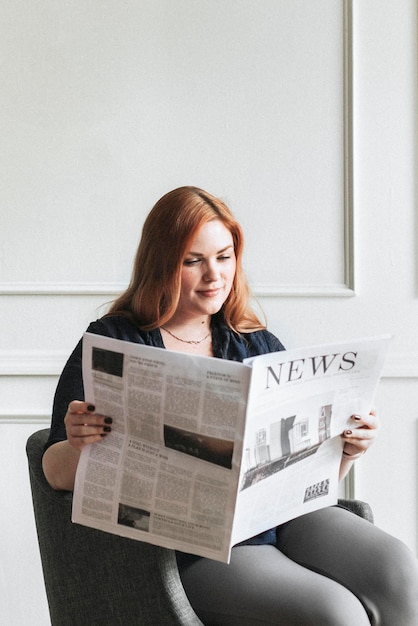 Femme lisant le journal à la maison