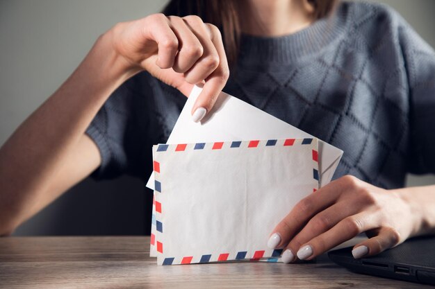 Femme lisant une lettre et travaillant sur ordinateur