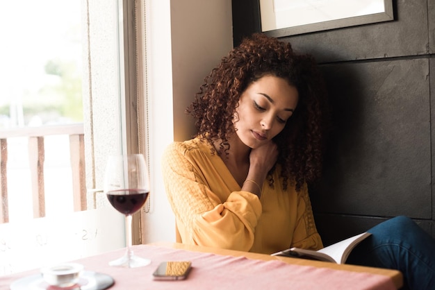 Femme lisant un livre au café