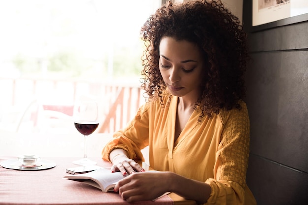 Femme lisant un livre au café