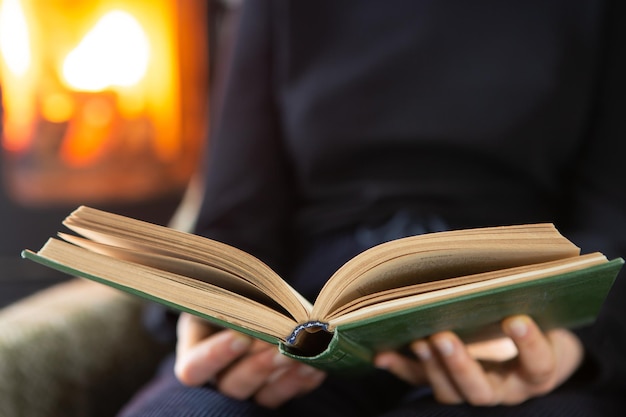 Femme lisant un livre au coin du feu Mode de vie hivernal confortable