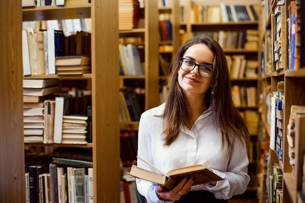 Femme lisant un livre dans la bibliothèque