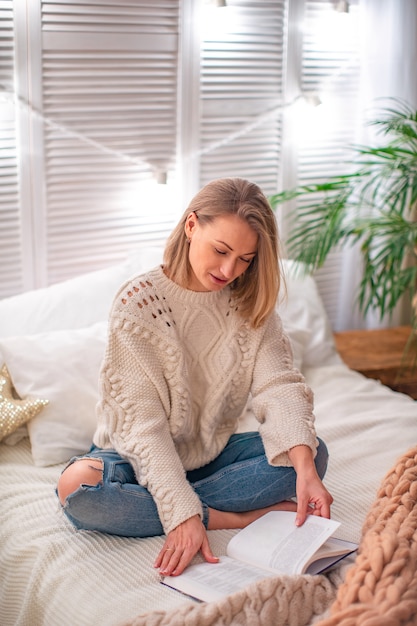 Femme lisant un livre sur le lit