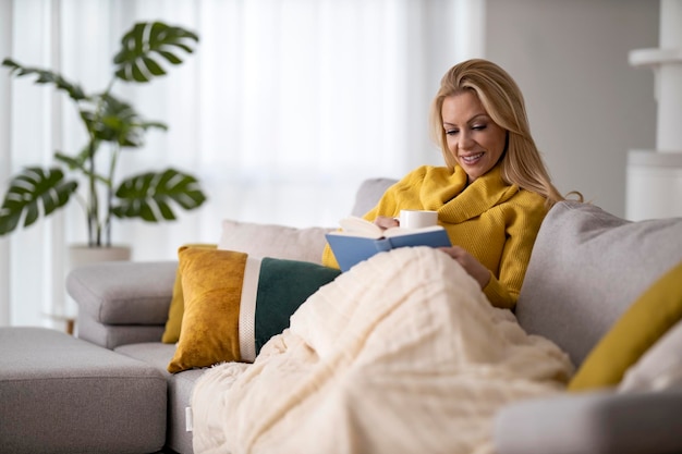 Femme lisant un livre à la maison