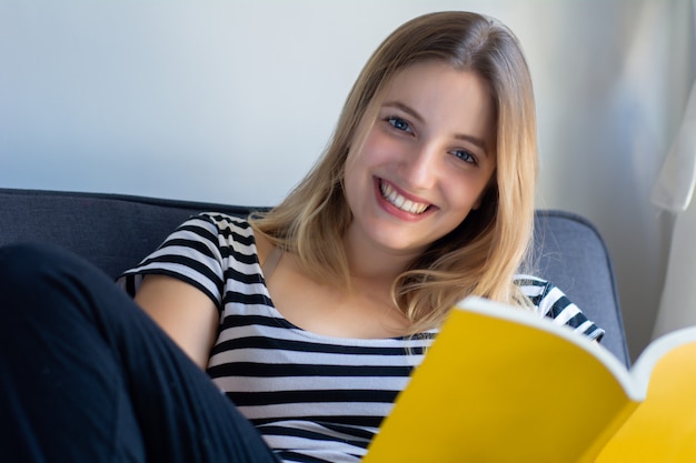 Femme lisant un livre à la maison