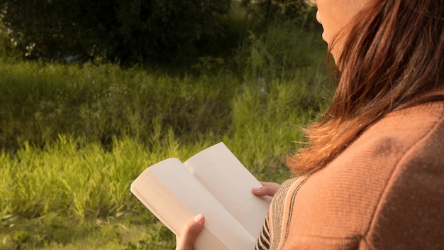 Photo la femme lisant le livre à la nature.