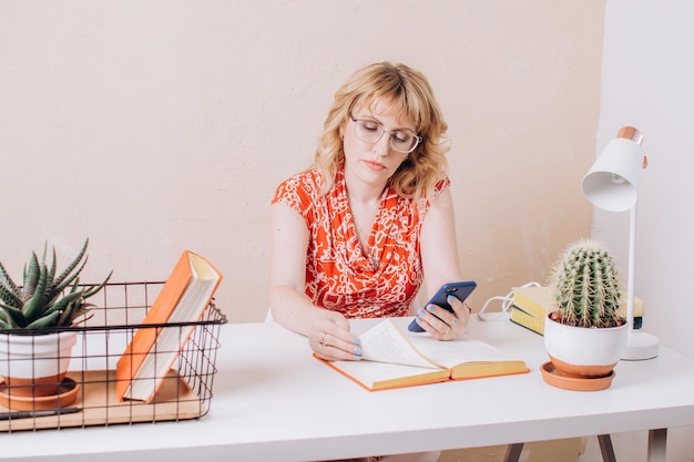 Femme lisant un livre et regardant le téléphone