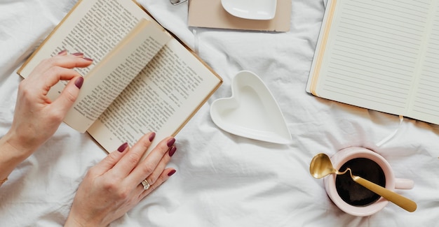 Femme lisant un roman sur son lit un dimanche après-midi