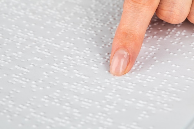 Une femme lit un livre écrit en braille