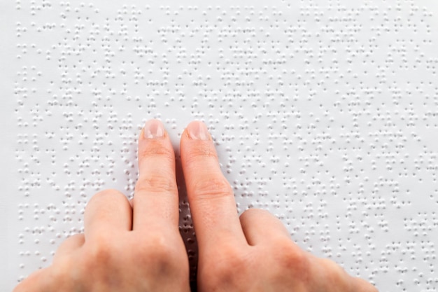 Une femme lit un livre écrit en braille