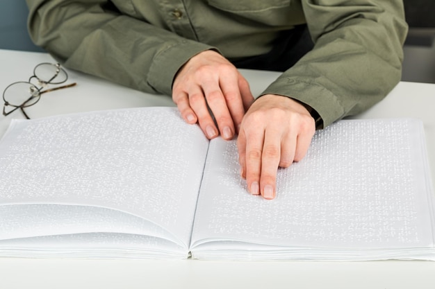 Une femme lit un livre écrit en braille