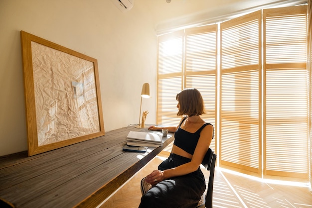 Une femme lit un magazine assise sur un lieu de travail confortable