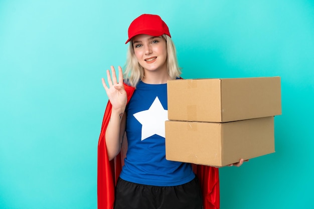 Femme de livraison caucasienne super héros isolée sur fond bleu heureuse et comptant quatre avec les doigts