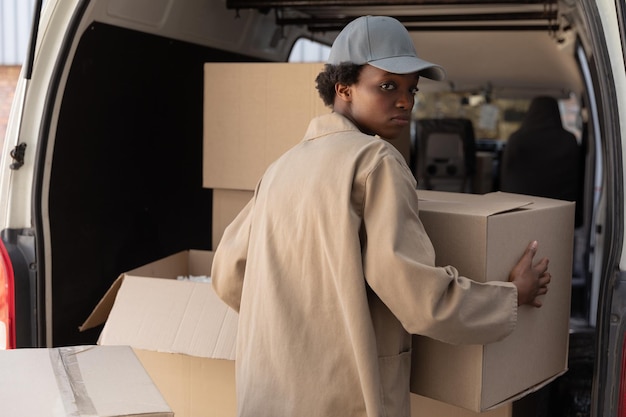 Photo une femme de livraison décharge des boîtes de carton d'un fourgon à l'extérieur de l'entrepôt