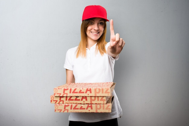 Femme de livraison de pizza en comptant un sur fond texturé