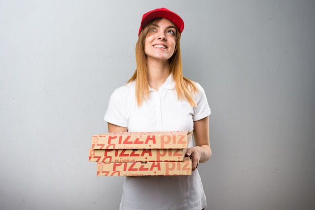 Femme de livraison de pizza en levant sur fond texturé