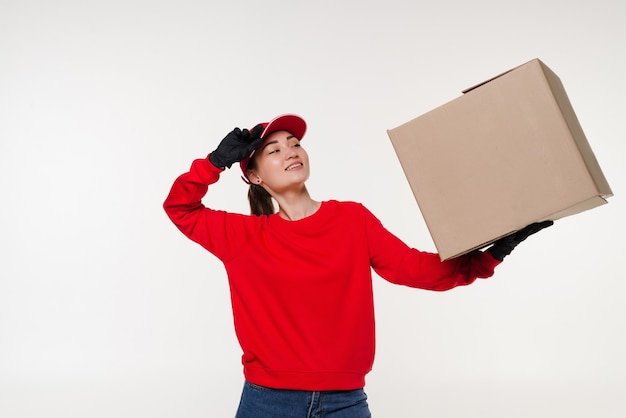 Femme de livraison transportant une boîte en carton isolé sur blanc