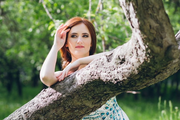 Photo femme en longue robe blanche dans le jardin d'été