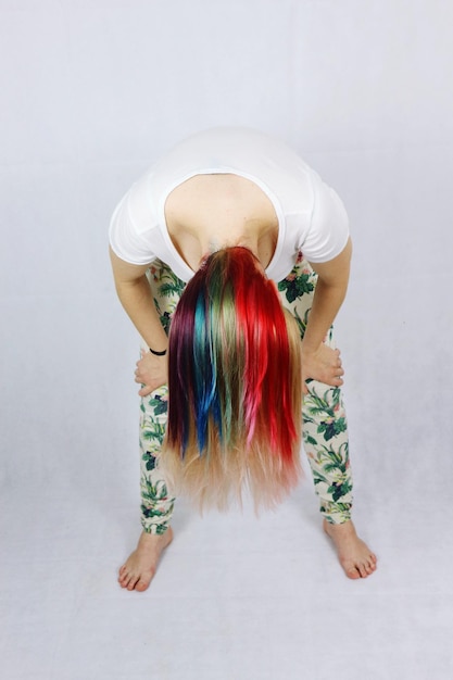 Photo une femme de longueur complète avec des cheveux teintés colorés se penchant sur un fond blanc