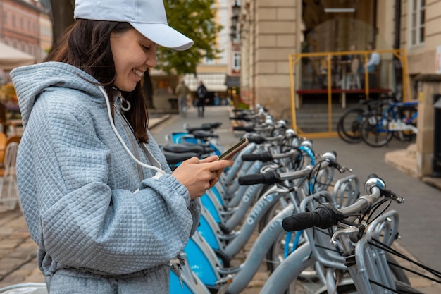 Femme louant un vélo de ville avec application mobile transport écologique moderne