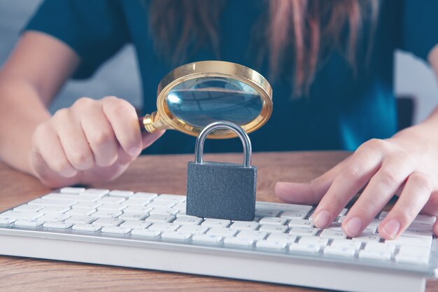 femme loupe regardant clavier avec serrure