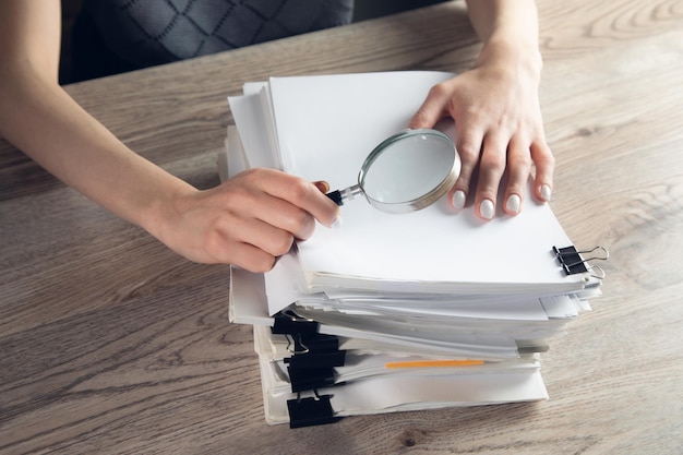 Photo femme avec loupe regardant des papiers