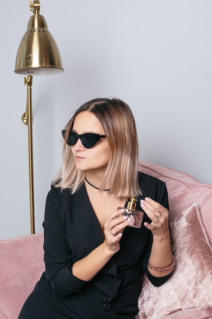 Femme en lunettes à la mode de protection solaire noir avec parfum