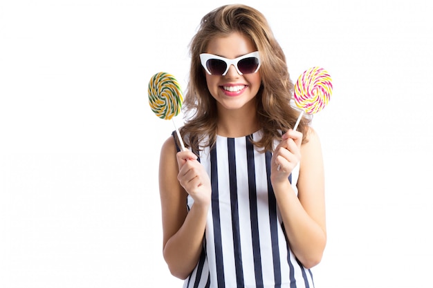 Femme à lunettes de soleil tenant une sucette.