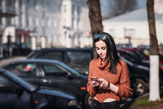 Femme avec des lunettes de soleil utiliser un smartphone mobile dans la rue.