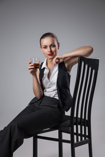 Photo femme mafieuse avec verre de cognac. photo de mode. style rétro